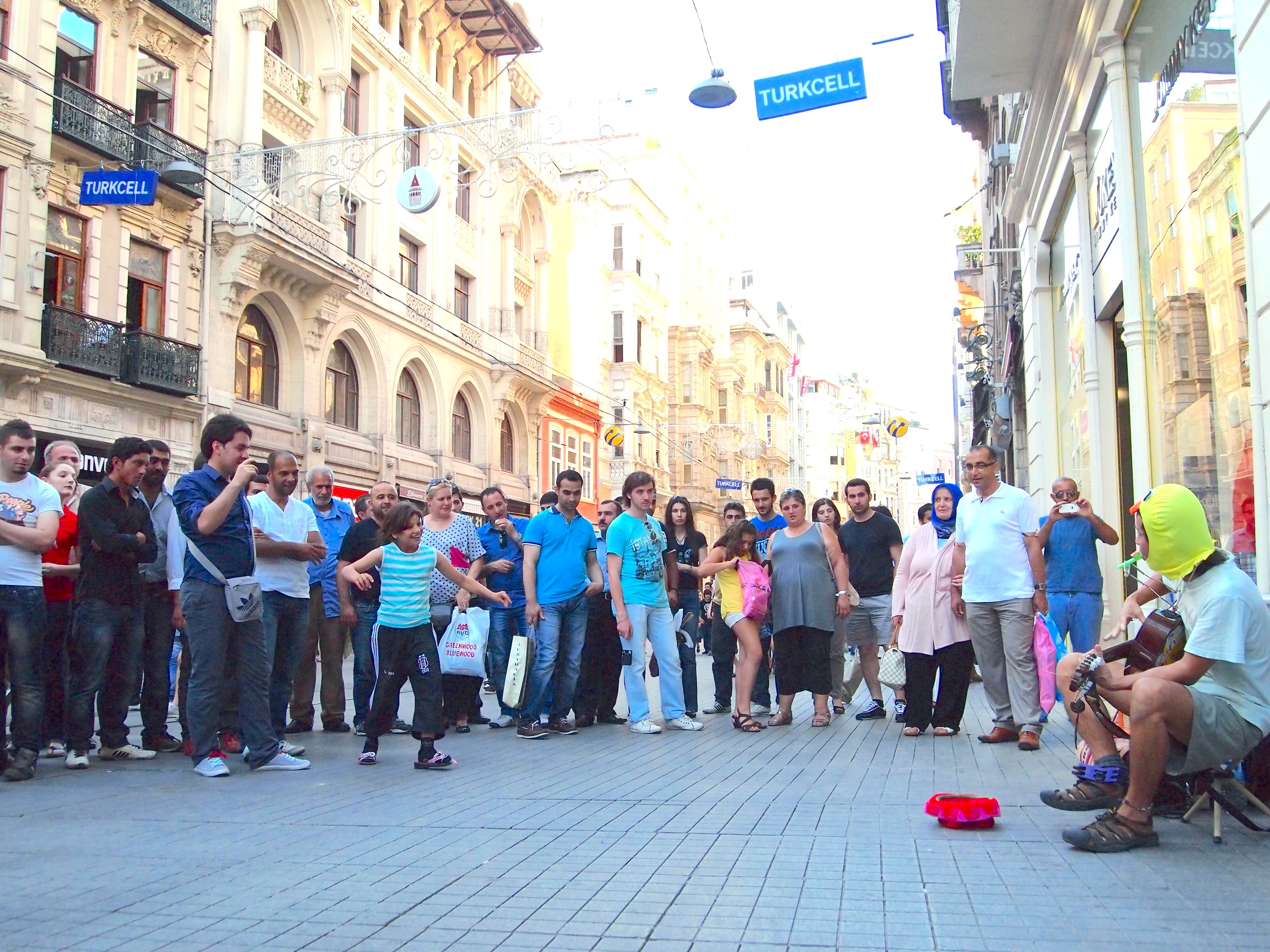 Turkey, 2012: Tony playing guitar in a duck hood for an audience gathered on the street